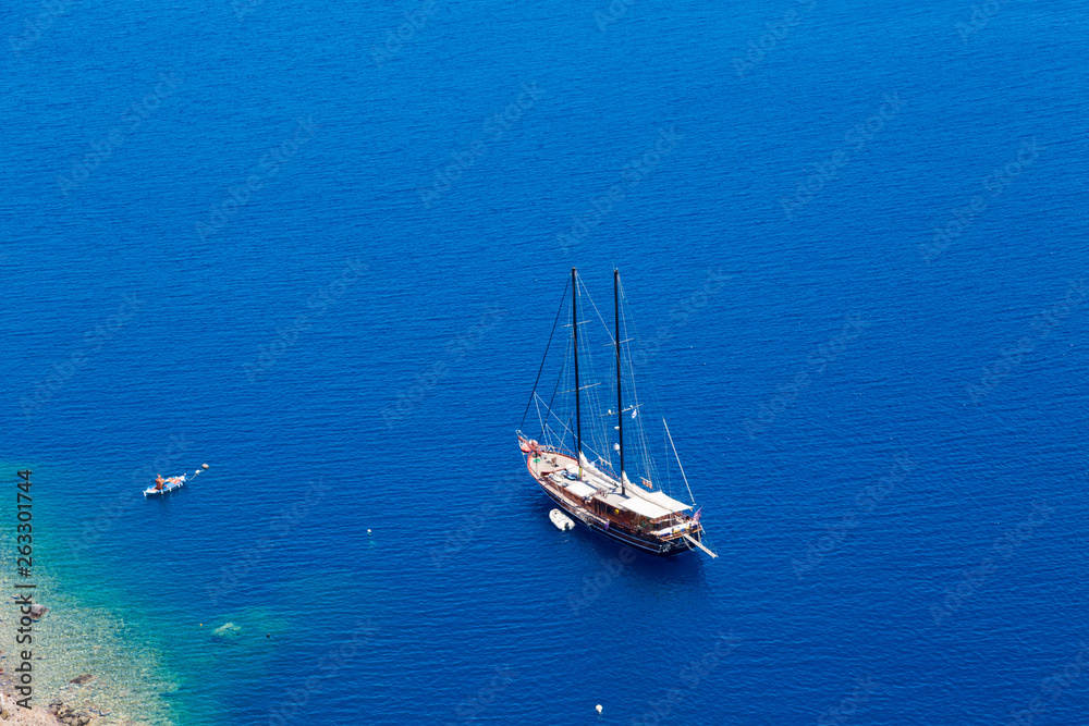 Santorini, Greece - July 07, 2017: Island Santorini. Luxury sailing yacht in the blue sea near the island Santorini, Greece - July 07, 2017: Island Santorini. Luxury sailing yacht in the blue sea near the island