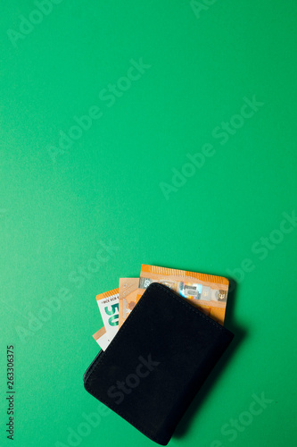 wallet with euro money on a green background