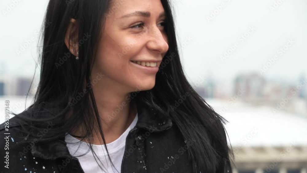 The girl looks into the camera and smiles sweetly.