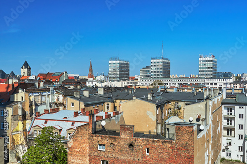 A panorama of the city of Poznań with modern skyscrapers and a tower of a Gothic church.