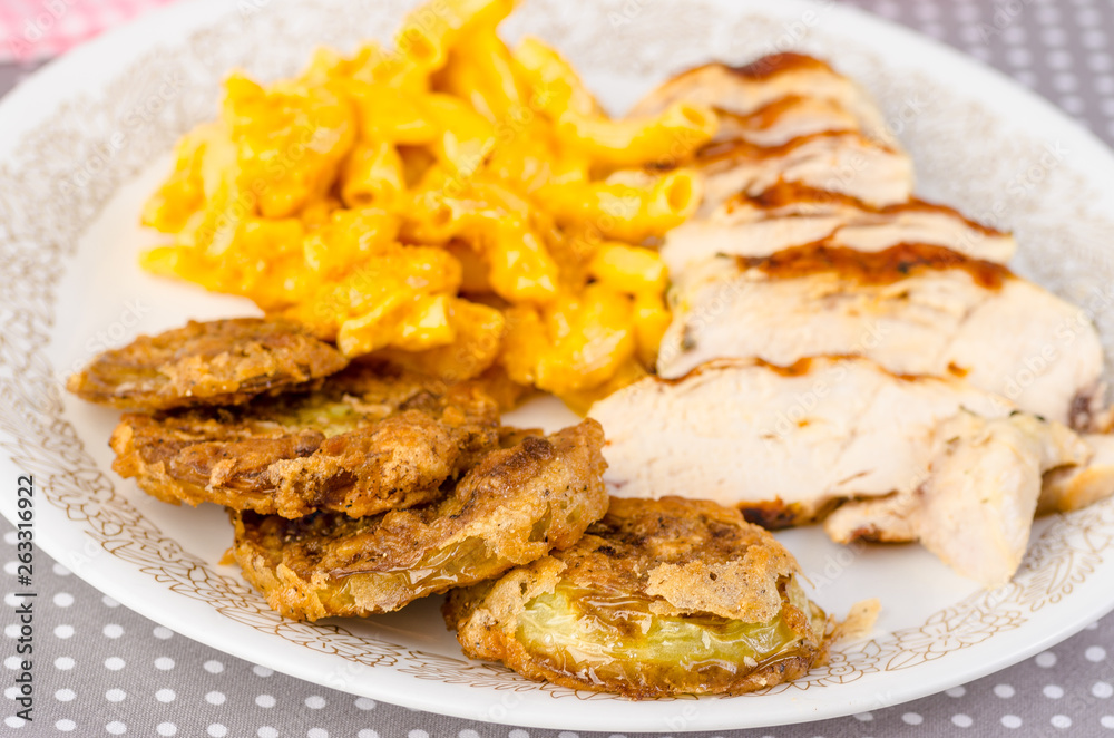 Selective Focus on Fried Green Tomatoes on Plate with Pork Tenderloin and Mac and Cheese.