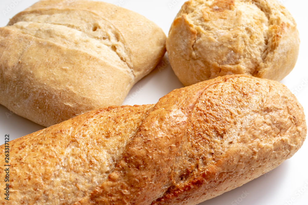 Assortment, different kind of wheat baked bread with golden crust on the table Assortment, different kind of wheat baked bread with golden crust on the table