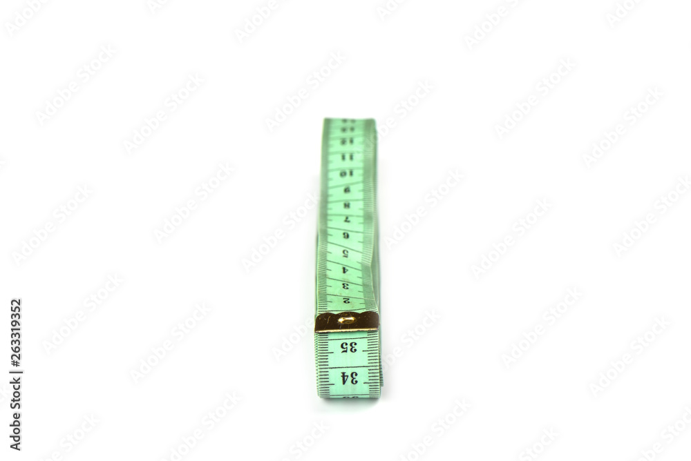 Soft focus. Tailoring centimeter tape twisted into a spiral isolated on a white background Soft focus. Tailoring centimeter tape twisted into a spiral isolated on a white background