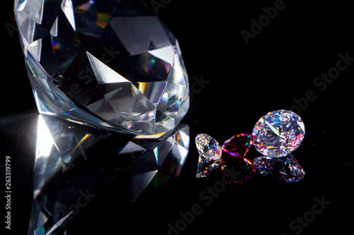 Huge diamond and several chic crystals on a deep black mirror surface, shimmer and sparkle