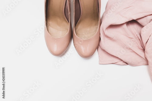 Fashionable concept, pastel beige shoes with high hills and delicate blouse on white background, sale, diascount and shopping concept with copy space