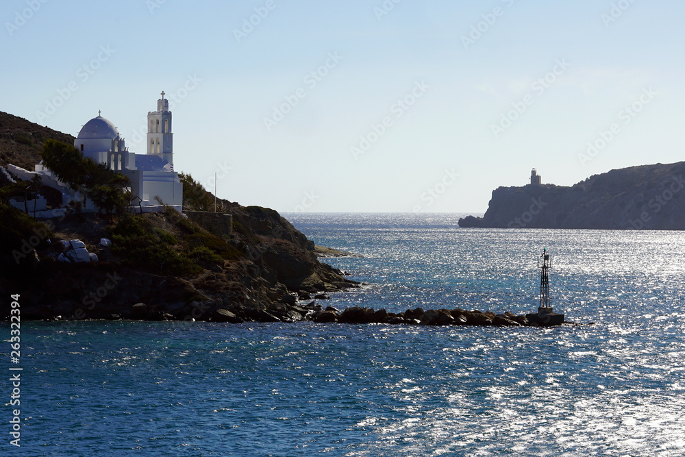 View of the entrance to the port of Ios with its lighthouse and the church of Saint Irene
