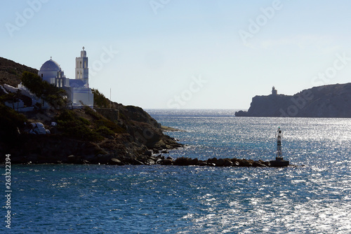View of the entrance to the port of Ios with its lighthouse and the church of Saint Irene © jekatarinka