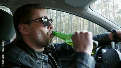 Close-up of Drunk driver drinking beer while driving, traffic offense