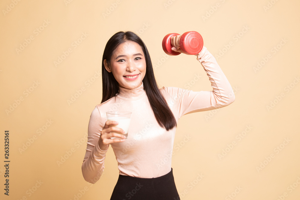 Healthy Asian woman drinking a glass of milk and dumbbell. Healthy Asian woman drinking a glass of milk and dumbbell.