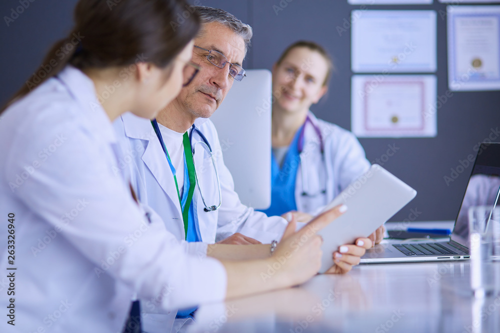 Serious medical team using a laptop in a bright office Serious medical team using a laptop in a bright office