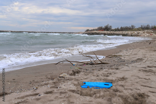 Environmental problem. Ecology concept. Plastic on the beach with sos writing. Spilled garbage on the beach