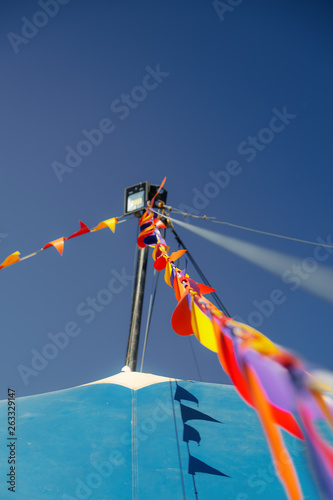 Macro of colored pennants waving with the wind in a blue circus tent