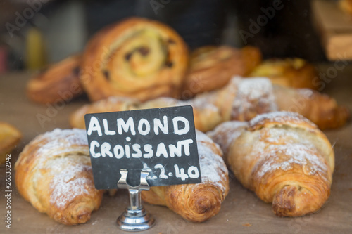 Croissants for sale in a shop window, with a shallow depth of field