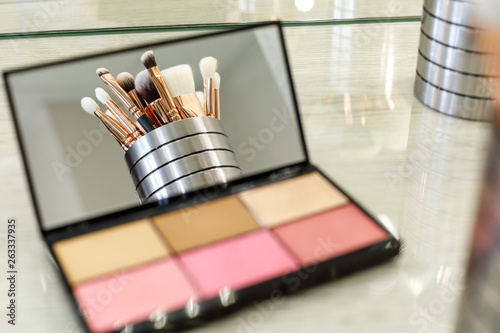 makeup brushes are reflected in a palette mirror with shadows photo