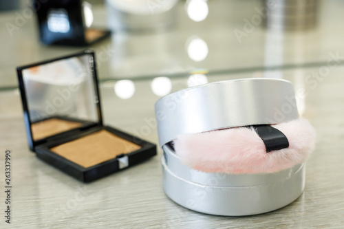 round box with powder and pink fur sponge and rouge in a square box in a beauty salon photo