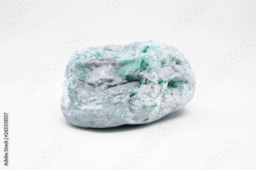 Natural raw mineral emerald nestled in gray bedrock close-up isolated on white background