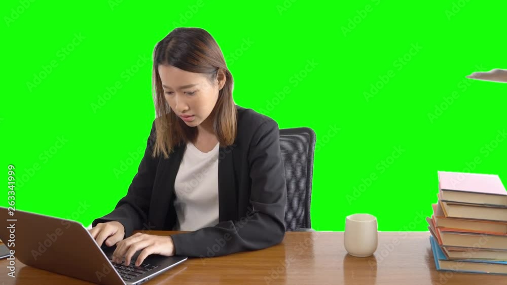 4K Medium shot selective focus of business woman sitting on the chair working on laptop on the table and receiving the document from her assistant in office with green screen or chroma key background. 4K Medium shot selective focus of business woman sitting on the chair working on laptop on the table and receiving the document from her assistant in office with green screen or chroma key background.