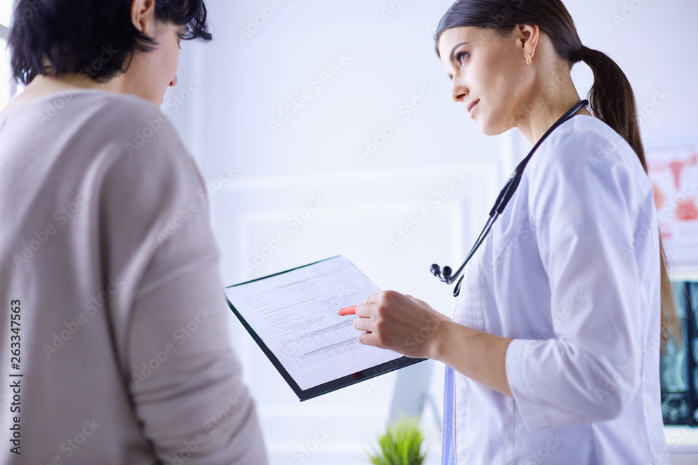 Beautiful female doctor explaining medical treatment to a patient Beautiful female doctor explaining medical treatment to a patient