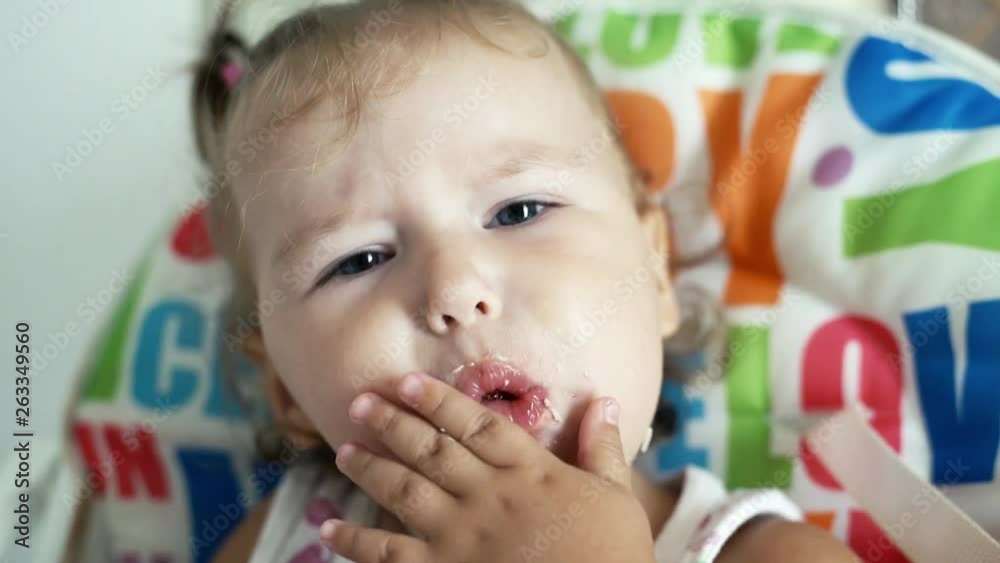 Cute little baby girl portrait funny eating red strawberries all smeared Cute little baby girl portrait funny eating red strawberries all smeared