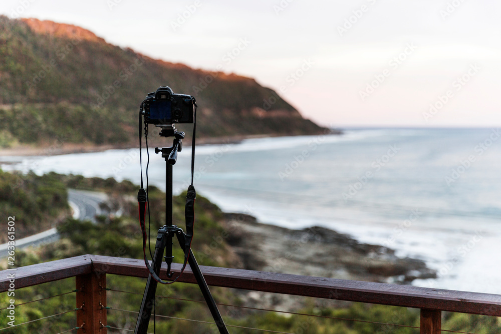 Naklejka premium Tripod & camera placed on top of holiday house decking.
