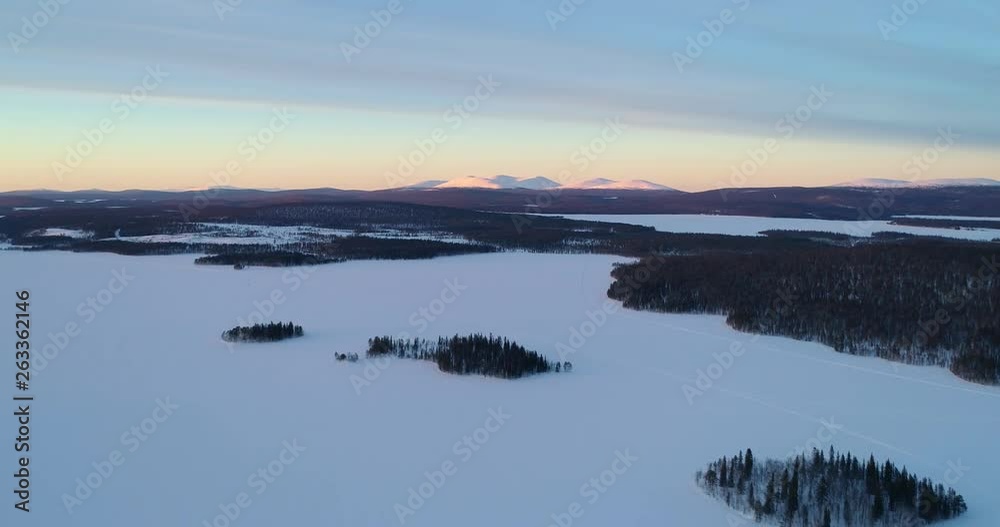 Aerial, drone shot, of Pallastunturi fells, Sarkijarvi lake and polar nature, in Pallas-yllastunturi national park, at the arctic circle, on a sunny, winter evening, in Muonio, Lapland, Finland