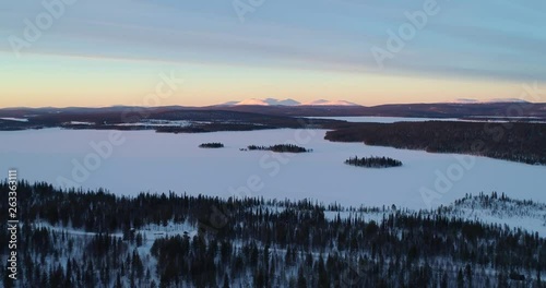 Aerial, drone shot, of Pallastunturi fells, Sarkijarvi lake and polar nature, in Pallas-yllastunturi national park, at the arctic circle, on a sunny, winter evening, in Muonio, Lapland, Finland photo