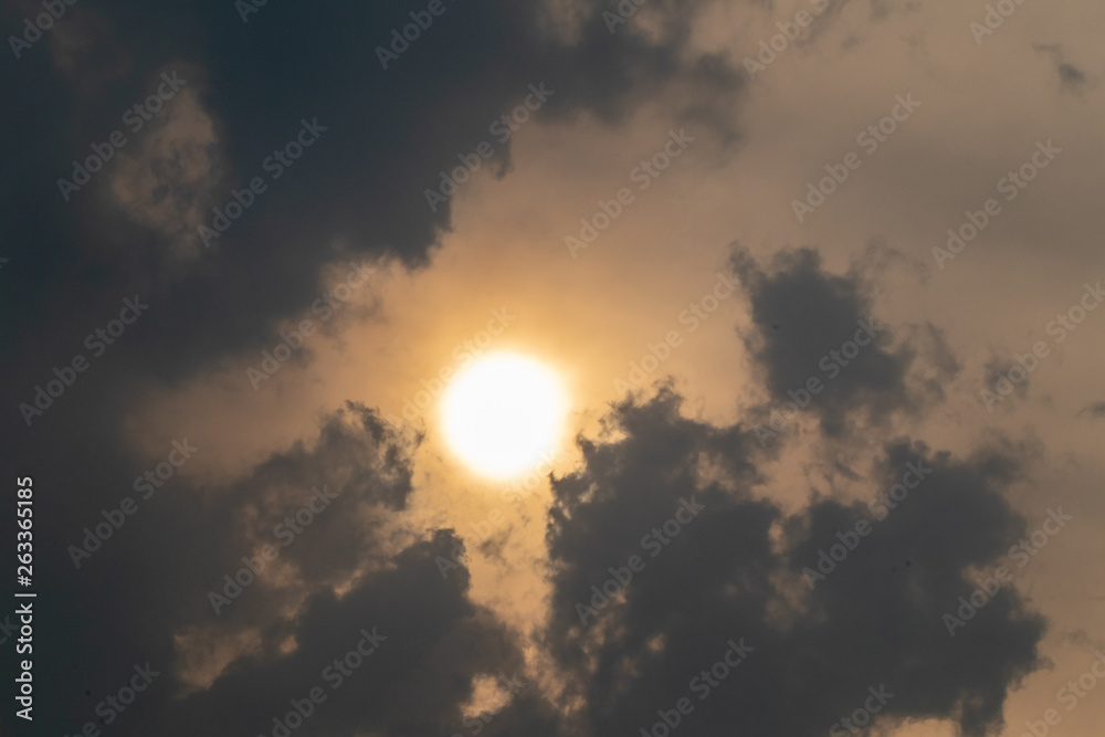 the sun hide behind grey cloud at evening