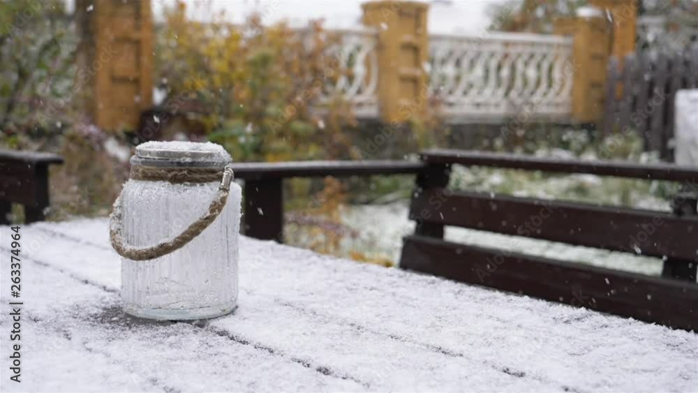 Pure white snow falling on te wooden table bench and retro glass bottle Pure white snow falling on te wooden table bench and retro glass bottle