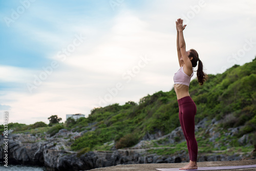 Side view of healthy women practicing yoga. standing in mountain exercise, Tadasana pose,. .beautiful landscape view sky on evening sunlight.