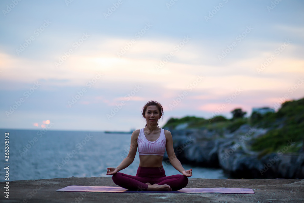 Healthy happy women practicing yoga. sitting in lotus pose meditation outdoors concentrating breathing asana yoga. .beautiful landscape view sky on evening sunset nature evening outdoor.