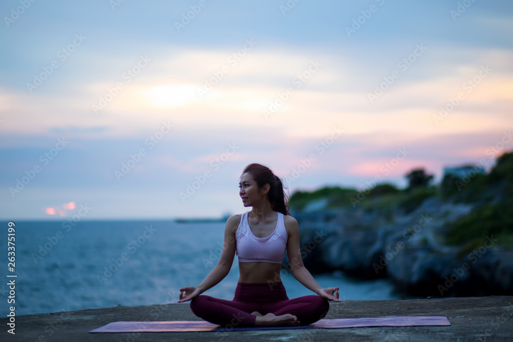 Healthy Feeling women practicing yoga. sitting in lotus pose meditation outdoors concentrating breathing asana yoga. .beautiful landscape view sky on evening sunset nature evening outdoor.