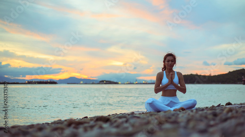 Healthy women practicing yoga. sitting in lotus pose meditation outdoors concentrating breathing asana yoga.Easy Pose. .landscape view sky on morning outdoor near sea
