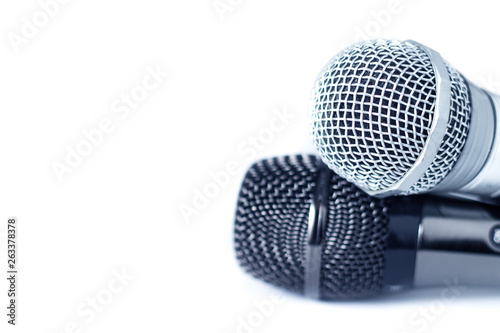 Two close-up of microphones on white background with copy space, selective focus