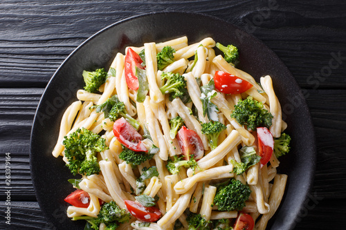 Dietary pasta Casarecce with vegetables dressed with creamy cheese sauce close-up on a plate. horizontal top view photo