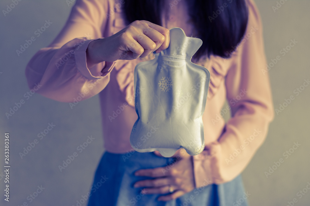 Close up woman has abdominal pain, woman's belly with hot water bottle
