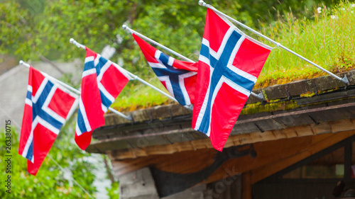 Norwegian flags on mossy roof house