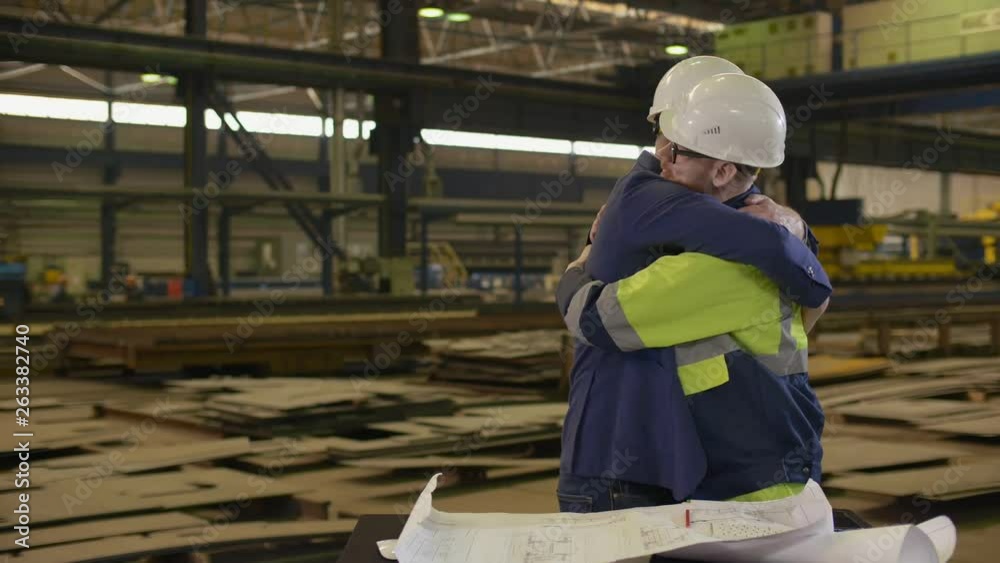Portrait of factory manager and worker hugging Portrait of factory manager and worker hugging