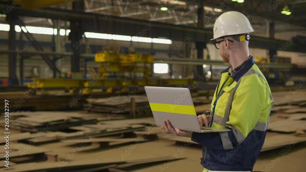 An industrial man engineer with laptop in a factory, working An industrial man engineer with laptop in a factory, working