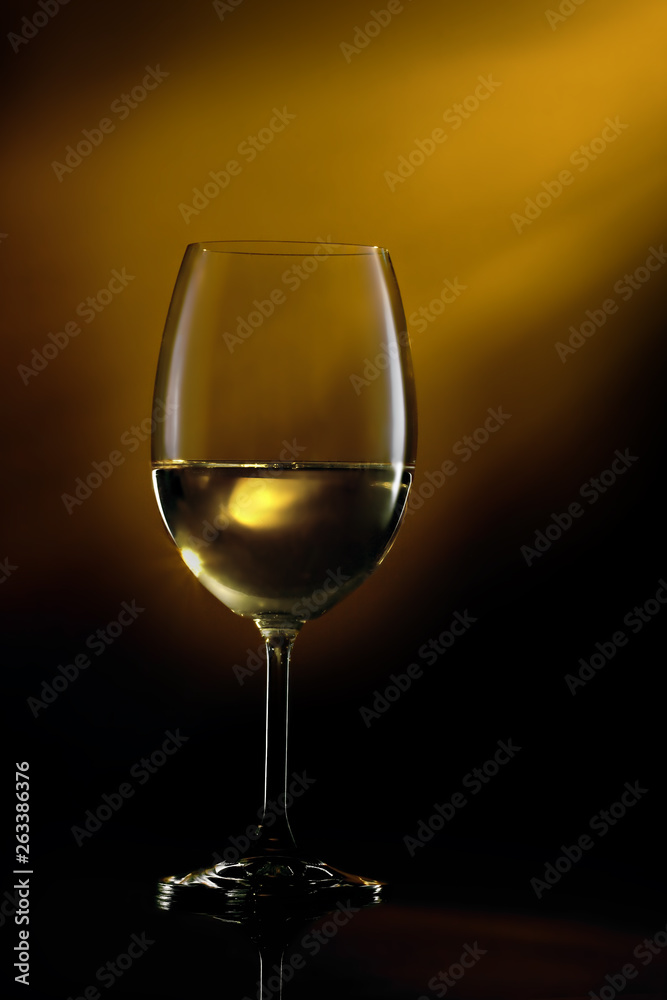 Glass filled with white wine on a gradient background. Close-up studio shot. Glass filled with white wine on a gradient background. Close-up studio shot.