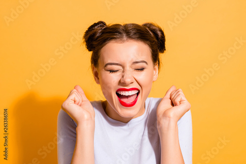 Close-up portrait of her she nice attractive fascinating lovely cheerful cheery crazy glam girl holding fists hope luck great success isolated over bright vivid shine yellow background