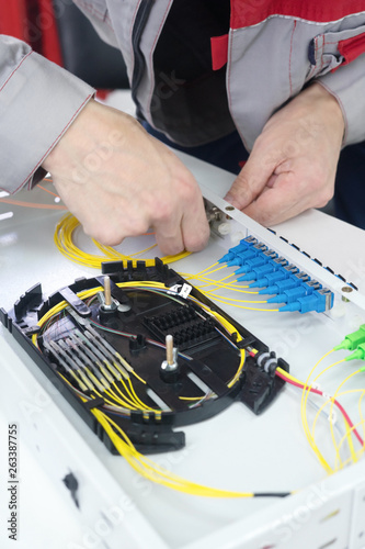 Splicing the fiber optic cable on spice tray with worker hands
