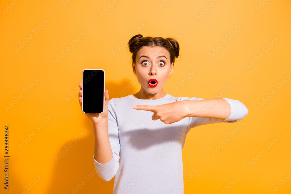 Attention sales discounts Portrait of astonished person impressed by incredible news information from social network pointing at mobile phone isolated over colorful background in white jumper Attention sales discounts Portrait of astonished person impressed by incredible news information from social network pointing at mobile phone isolated over colorful background in white jumper