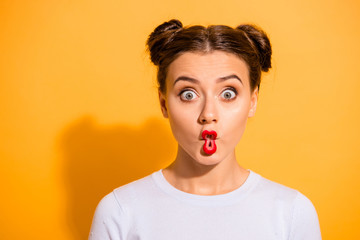 Close up photo beautiful she her lady pretty hairdo two buns big eyes fish-face foolish ridiculous hilarious idiotic facial expression wear casual white pullover clothes isolated yellow background