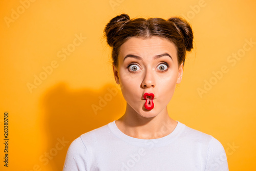 Close up photo beautiful she her lady pretty hairdo two buns big eyes fish-face foolish ridiculous hilarious idiotic facial expression wear casual white pullover clothes isolated yellow background photo