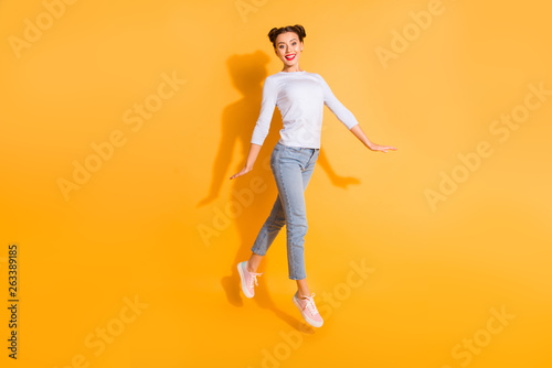 Full length body size photo of adorable funny student walking promenade satisfied wearing white cotton pullover denim clothes pink sneakers on colorful background