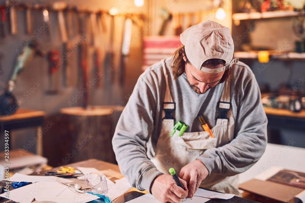 Male carpenter fixing old wood in a retro vintage workshop.