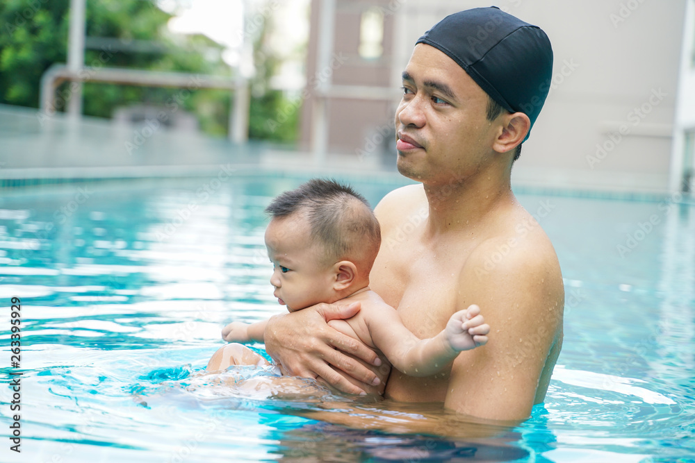Father swimming with adorable little baby boy