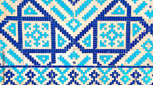colorful ancient traditional Uzbek pattern on the ceramic tile on the wall of the mosque, abstract background