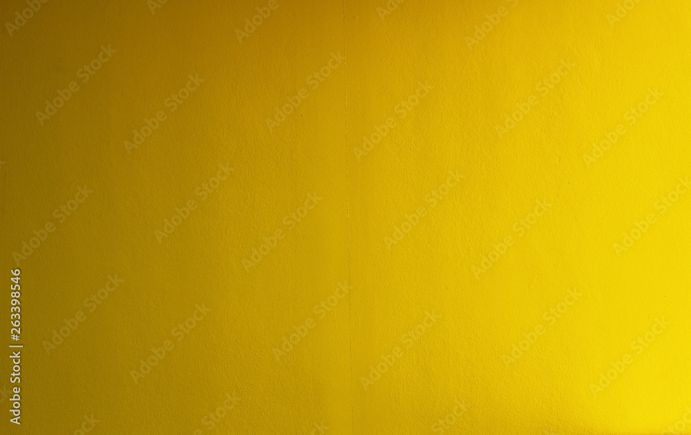 Fototapeta premium Yellow concrete stucco wall useful for backgrounds or textures