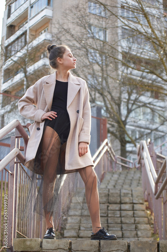 dancer posing in a city on a stairway in a black leotard.